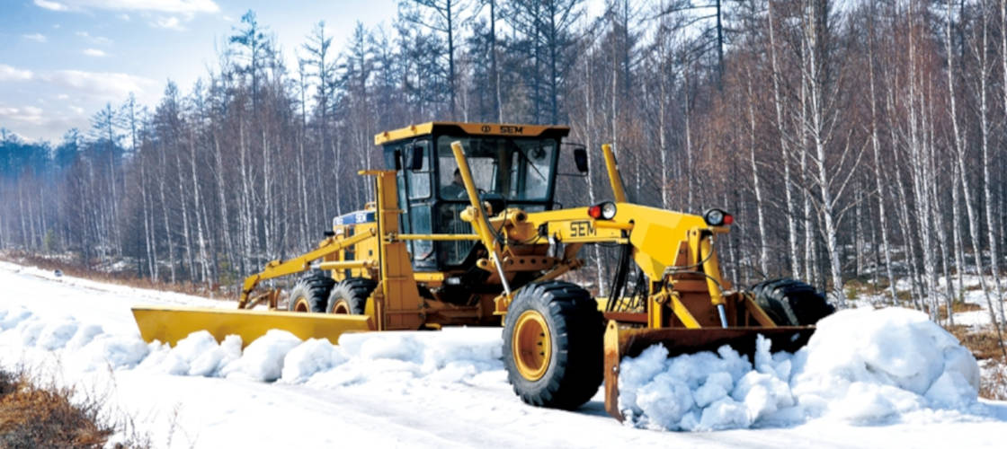 Автогрейдер SEM розчищає дорогу від снігу